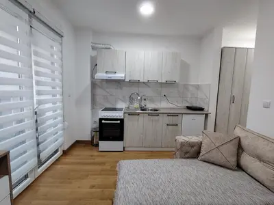 a living room with a couch and a kitchen at Apartman Peca in Vrnjci