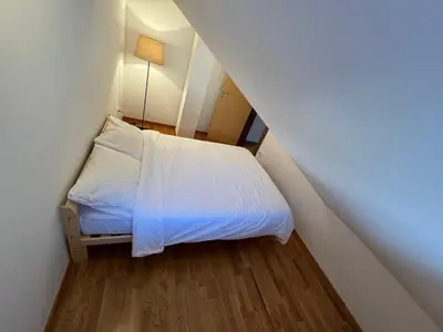 a small bedroom with a white bed in a attic at Eli's APARTMENT 31 in Brzeće
