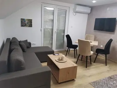 a living room with a couch and a table and chairs at Apartmani Vila Dragana Vrnjačka Banja in Vrnjci