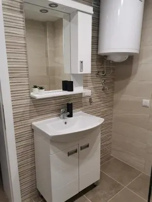 a bathroom with a white sink and a mirror at Apartmani Vila Dragana Vrnjačka Banja in Vrnjci