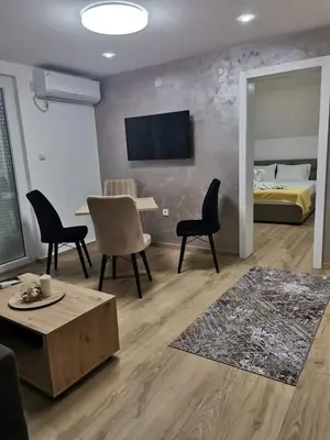 a living room with a bed and a table and chairs at Apartmani Vila Dragana Vrnjačka Banja in Vrnjci