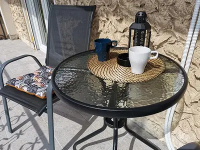 a glass table with two coffee cups on it at Apartmani Vila Dragana Vrnjačka Banja in Vrnjci