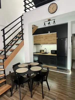 a kitchen and dining room with a table and chairs at Central Duplex Apartment in Zaječar