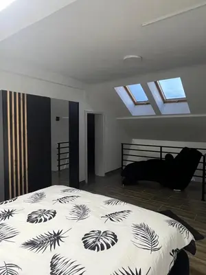 a bedroom with a bed with a black and white comforter at Central Duplex Apartment in Zaječar