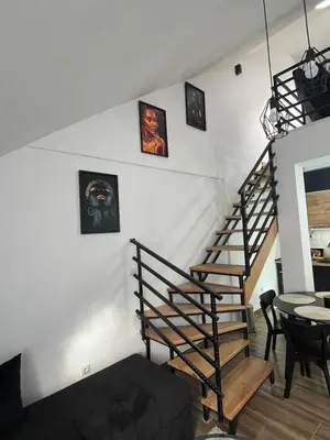a staircase in a living room with pictures on the wall at Central Duplex Apartment in Zaječar