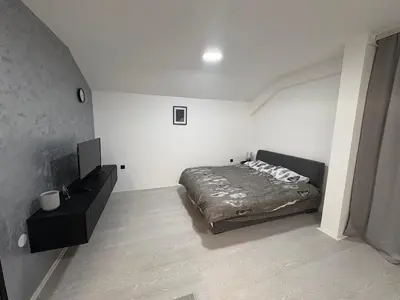 a bedroom with a bed and a television in it at Fenix Apartman III in Zaječar