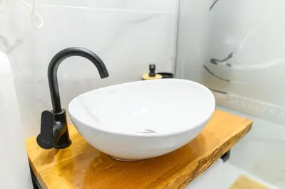 a bathroom with a white bowl sink on a wooden counter at DANESTRA Sokobanja in Soko Banja