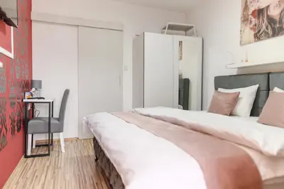 a bedroom with a large bed and a chair at DANESTRA Sokobanja in Soko Banja