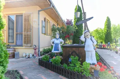 a garden with statues in front of a house at DANESTRA Sokobanja in Soko Banja