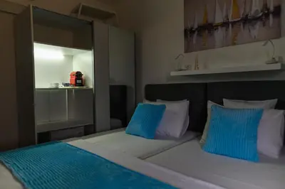 a bedroom with a bed with blue and white pillows at DANESTRA Sokobanja in Soko Banja