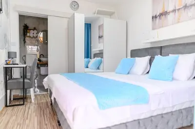 a bedroom with a large white bed with blue pillows at DANESTRA Sokobanja in Soko Banja