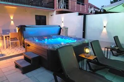 a hot tub in the middle of a patio at Apartmani HARMONIJA - Sokobanja in Soko Banja