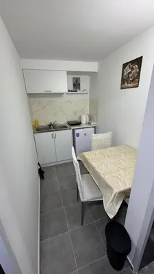 a small kitchen with a table and chairs in a room at Lucky Apartments in Leskovac