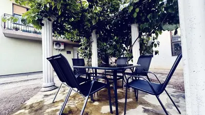 a black table and chairs sitting under a tree at Lucky Apartments in Leskovac