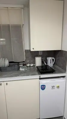 a kitchen with white cabinets and a white refrigerator at Lucky Apartments in Leskovac