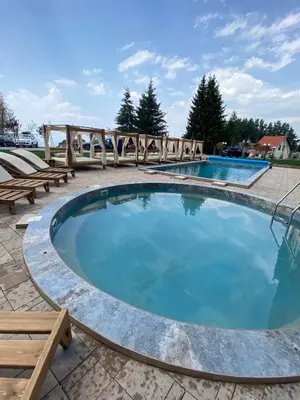 a large swimming pool with benches around it at Residence Hill Chill on Kop Apartment in Kopaonik