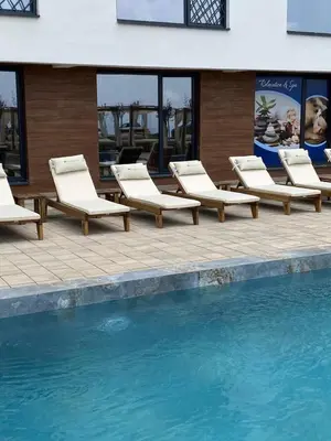 a group of lounge chairs next to a swimming pool at Residence Hill Chill on Kop Apartment in Kopaonik
