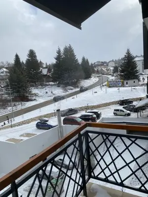 a view of a parking lot in the snow from a balcony at Residence Hill Chill on Kop Apartment in Kopaonik