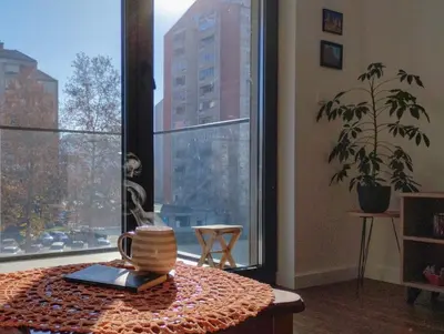 a room with a table and a large window at Planet Residence-Studio Solis in Niš