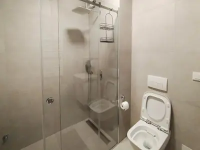 a bathroom with a toilet and a glass shower at Planet Residence-Studio Solis in Niš