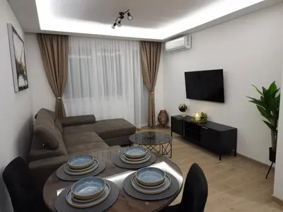 a living room with a couch and a table at ANDREAS lux apartman in Niš