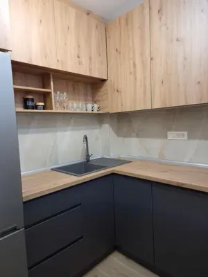 a kitchen with a sink and wooden cabinets at ANDREAS lux apartman in Niš