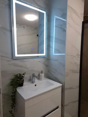 a bathroom with a white sink and a mirror at ANDREAS lux apartman in Niš