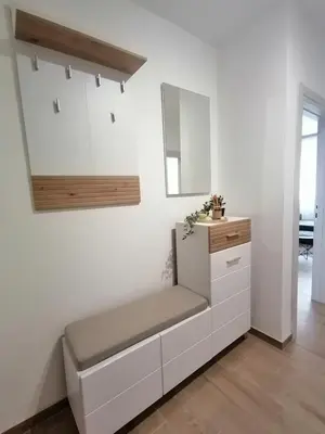 a white kitchen with a bench and a mirror at ANDREAS lux apartman in Niš