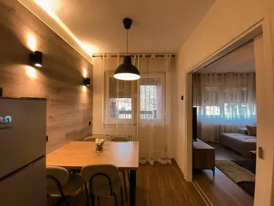 a kitchen and dining room with a table and chairs at Bagi Apartmani in Raška