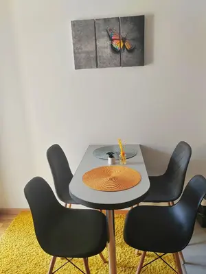 a table with chairs and a butterfly on the wall at For You in Vrnjci