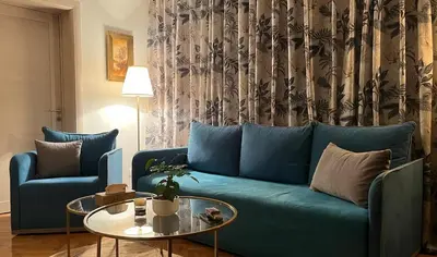 a blue couch in a living room with a table at Winona apartment in Niš