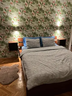 a bedroom with a bed with a floral wallpaper at Winona apartment in Niš