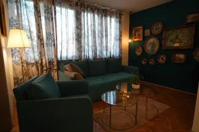 a living room with a green couch and a table at Winona apartment in Niš