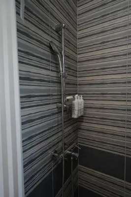 a shower in a bathroom with a hose at Winona apartment in Niš