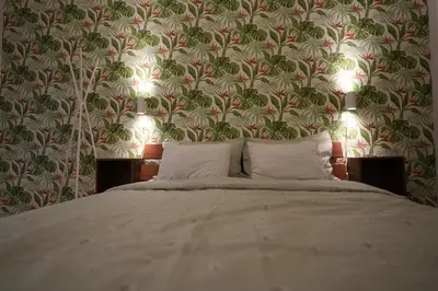 a bedroom with a bed with a floral wallpaper at Winona apartment in Niš