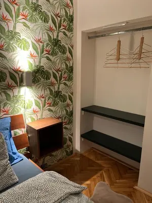 a bedroom with a bed and a tv and a wall at Winona apartment in Niš