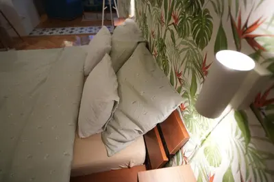 a bed with white sheets and pillows on it at Winona apartment in Niš