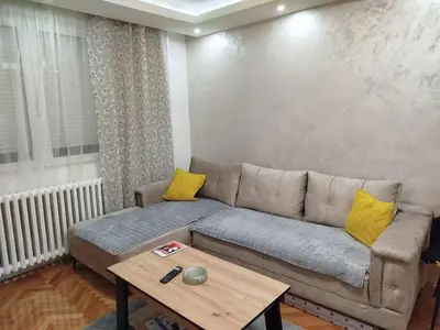 a living room with a couch and a table at Stan na dan in Niš