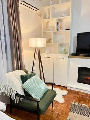 a living room with a chair and a lamp at Apartman Ogledalce, 51m2, potpuno opremljeno, Kruševac Smeštaj in Kruševac