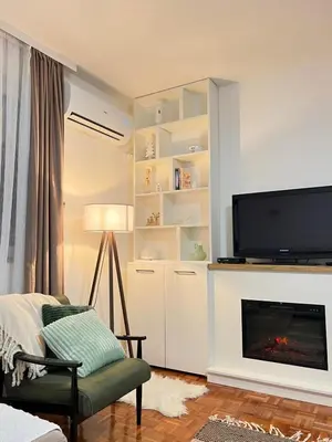 a living room with a fireplace and a flat screen tv at Apartman Ogledalce, 51m2, potpuno opremljeno, Kruševac Smeštaj in Kruševac
