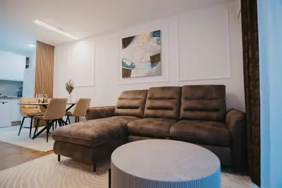 a living room with a couch and a table at Residence Lux apartman & Spa in Niš