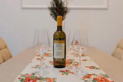 a bottle of wine sitting on a table with two wine glasses at Residence Lux apartman & Spa in Niš