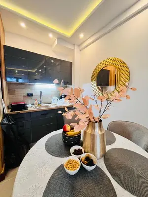 a kitchen with a table with a vase of flowers at Gold Apartments Kopaonik in Kopaonik