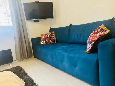 a blue couch with two pillows in a living room at Gold Apartments Kopaonik in Kopaonik