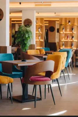 a group of chairs and tables in a restaurant at Gold Apartments Kopaonik in Kopaonik