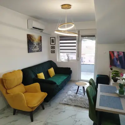 a living room with a green couch and yellow chairs at Cera maximus apartment in Soko Banja