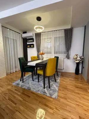 a dining room with a black table and yellow chairs at KARENJINA Apartmani in Vranje