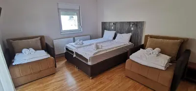 a bedroom with a bed and two chairs at Villa MILSA Half Board & Pool in Soko Banja