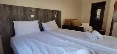 a large bed with white sheets and pillows at Villa MILSA Half Board & Pool in Soko Banja