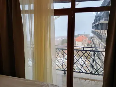 a bedroom window with a view of a bridge at Apartman Simona President Kop in Kopaonik
